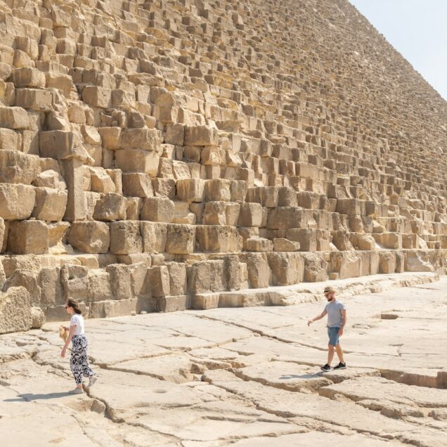 woman in blue denim jacket walking on brown sand during daytime